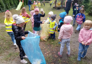 Dzieci sprzątają ogród przedszkolny
